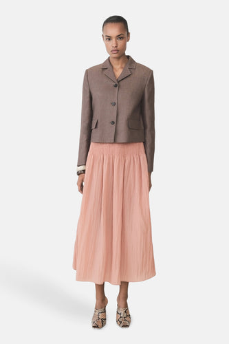 Roze rok van MANGO, gecombineerd met een bruin jasje en schoenen met slangenprint.
