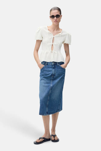 Witte blouse met korte mouwen van MANGO, met open detail en gedragen met een denim rok.
