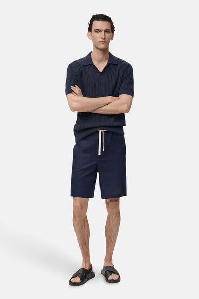 Short bleu de MANGO, avec cordon et porté avec un t-shirt et des sandales.