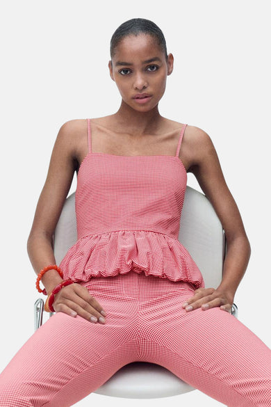 Rode mouwloze blouse van MANGO met een rood-wit geruit patroon en ruches onderaan.