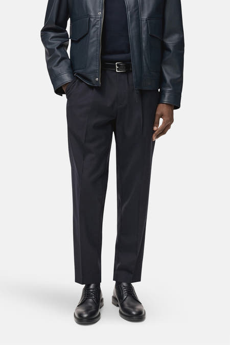 Blauwe kostuumbroek van MANGO, met een zwarte riem en zwarte leren schoenen.