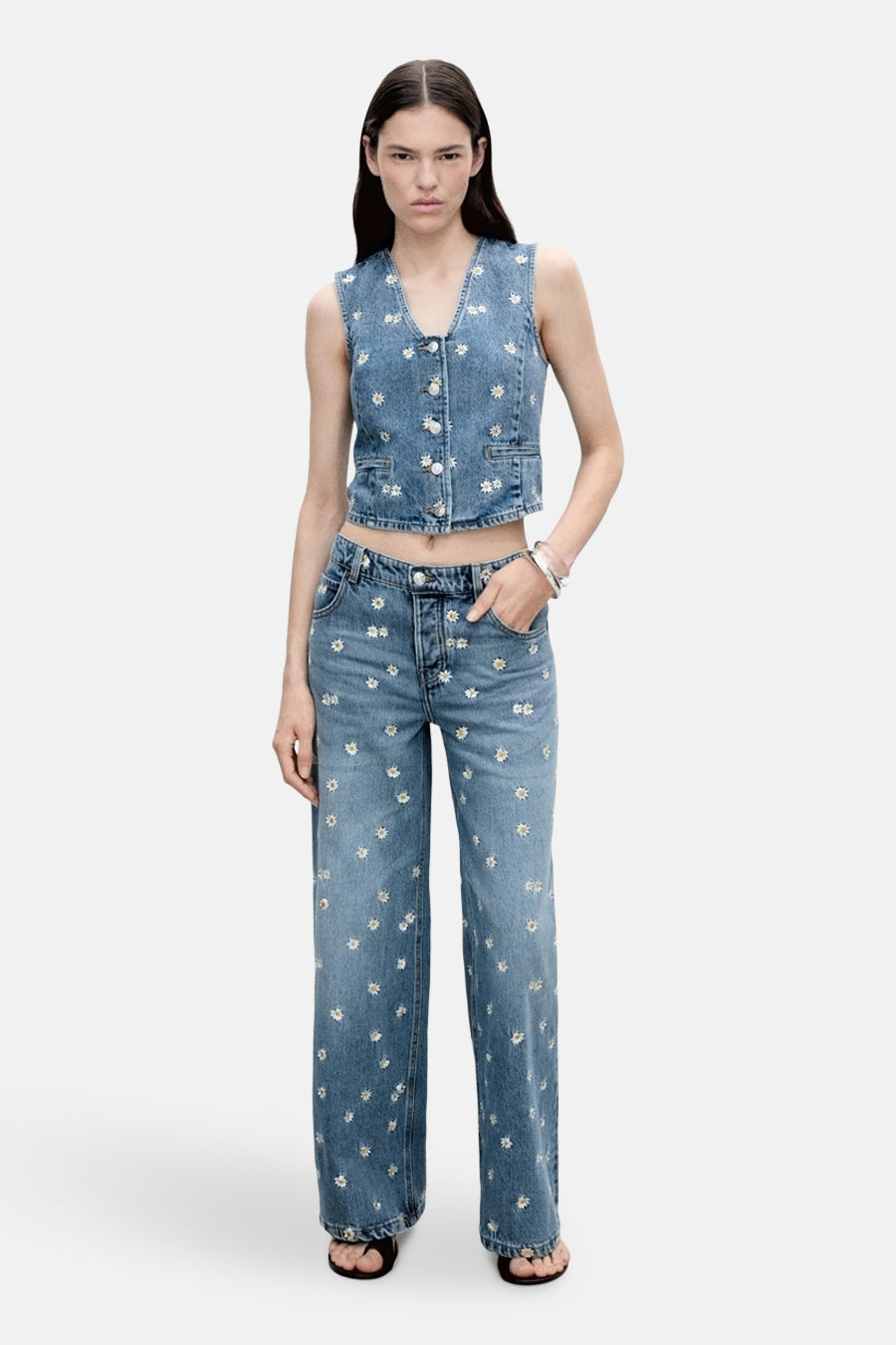 Middenblauwe denim blazer van MANGO, versierd met madeliefjes en gecombineerd met een bijpassende jeans en zilveren armband.
