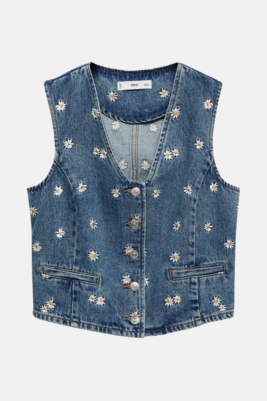 Mouwloze spijkerblazer in mid blue denim van MANGO, met geborduurde madeliefjes en zilverkleurige knopen.
