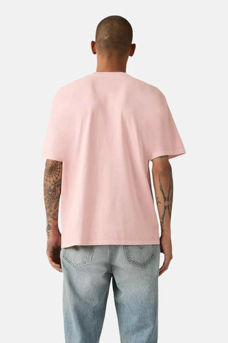 Roze T-shirt met korte mouwen van Levi's, met tatoeages op beide armen en een blauwe jeans.
