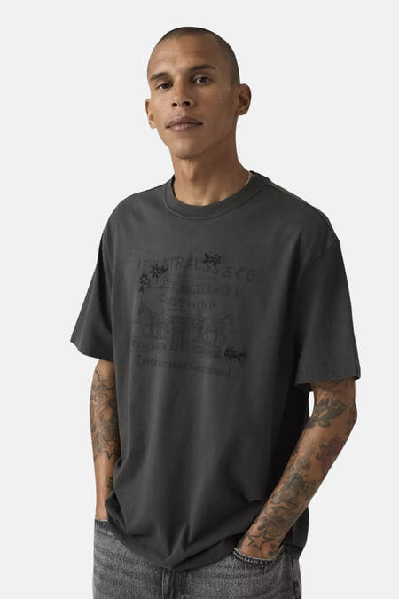 Zwart T-shirt van Levi's met een vintage print op de voorkant, gedragen door een model met tatoeages.

