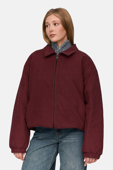 Rode jas van 24 colours gmbh, met corduroy textuur, een ritssluiting en blauwe jeans.
