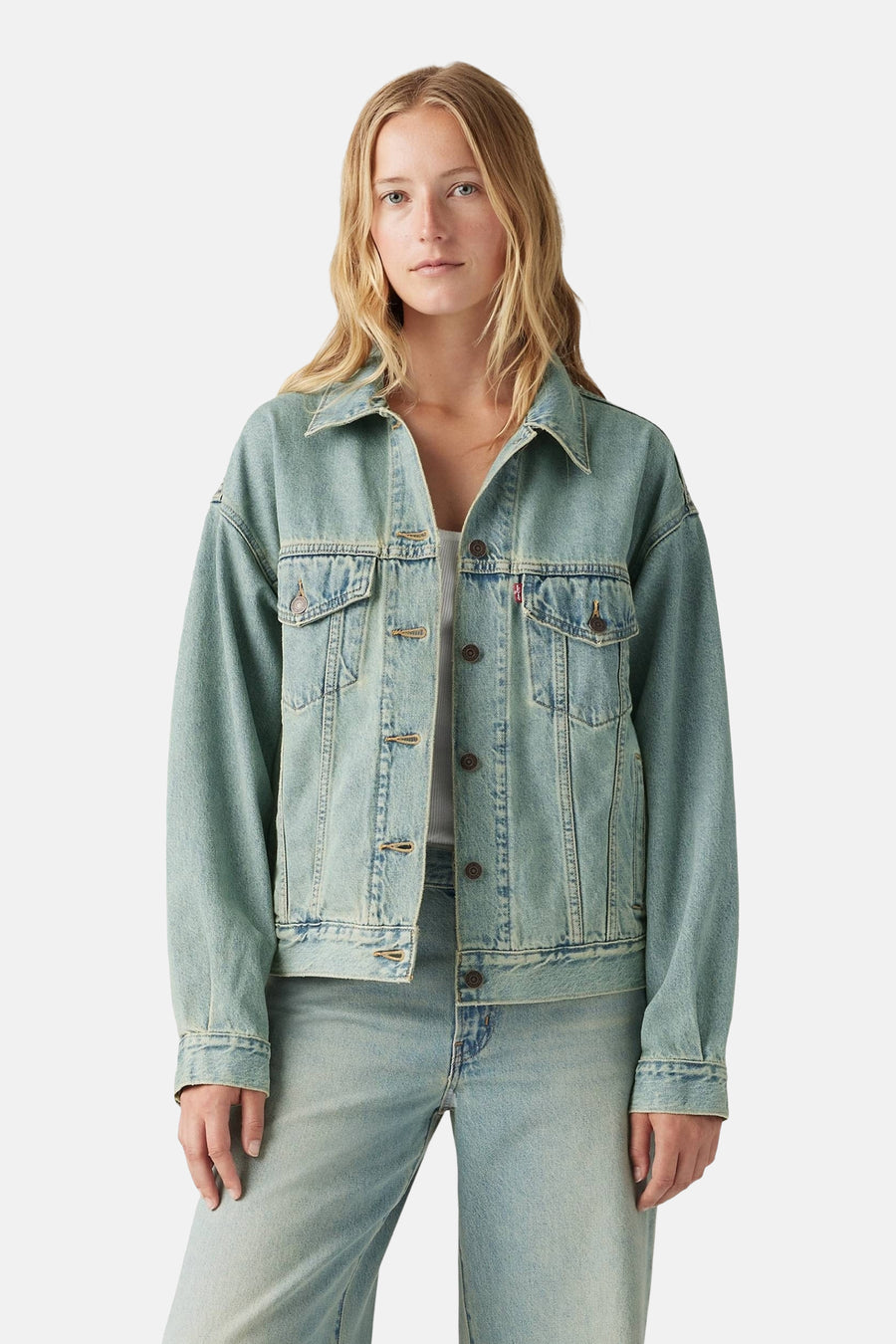 Lichtblauwe denim jeansjas van Levi's®, met knoopsluiting, borstzakken en gedragen op een jeansbroek.