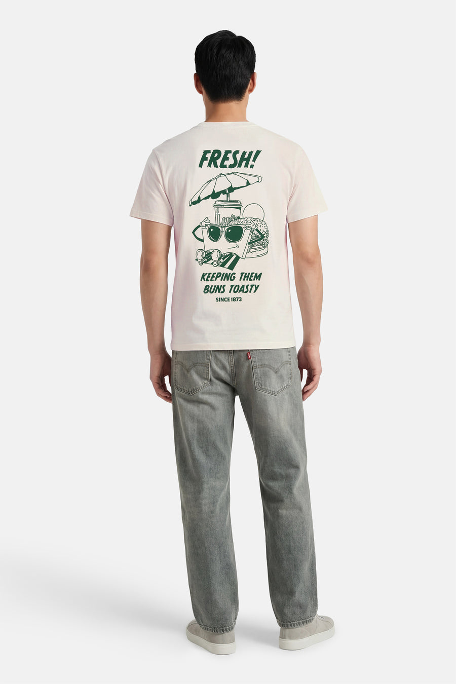 Beige T-shirt met korte mouwen van Levi's® met een grafische print op de rug, gecombineerd met grijze jeans.