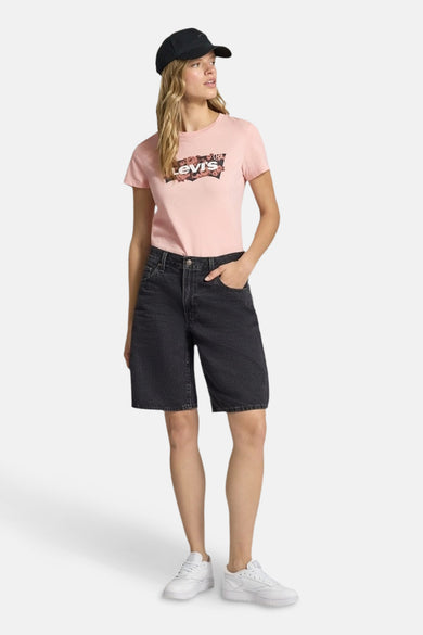 T-shirt rose à manches courtes de Levi's, avec une impression graphique, porté avec un short de jeans noir et des baskets blanches.