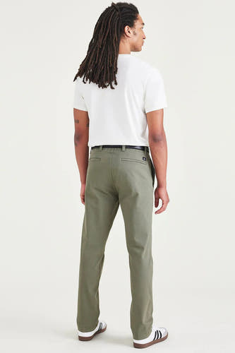Groene chino van DOCKERS, achterkant, met een zwarte riem, gecombineerd met een wit T-shirt en sneakers.
