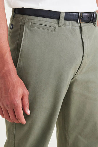 Groene katoenen chino broek met zwarte leren riem.
