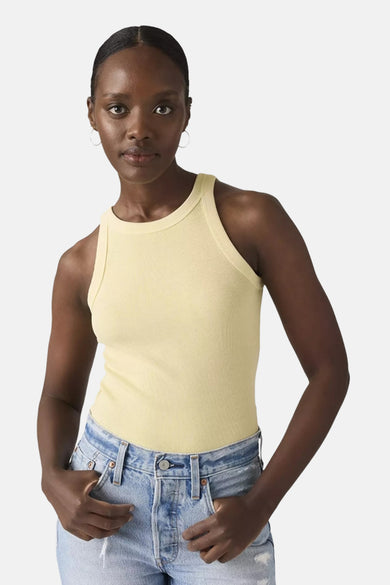 Gele tanktop van Levi's, gedragen met een blauwe spijkerbroek en zilveren oorringen.