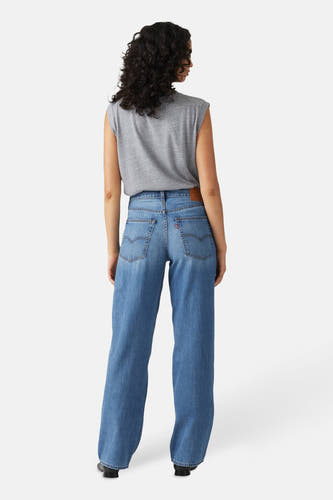 Jeans straight mid blue denim van Levi's, gezien van achteren, met een grijze top en zwarte schoenen.
