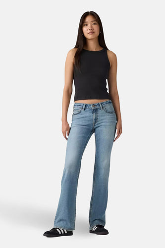 Middenblauwe denim bootcut jeans van Levi's, gedragen met een zwarte top en zwarte sneakers.