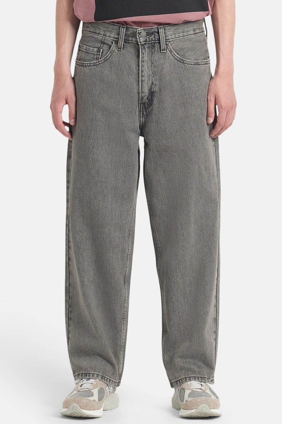 Jean ample gris foncé de Levi's, avec poches italiennes et porté avec des baskets beiges.