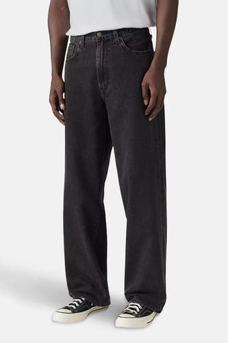 Wijde jeans van donkergrijs denim van Levi's®, gecombineerd met witte sneakers en een wit shirt.