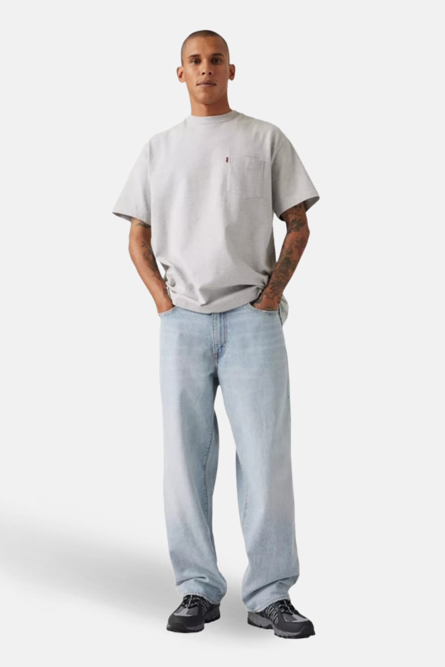 Jean bleu clair large de Levi's, porté avec un t-shirt gris et des chaussures noires.