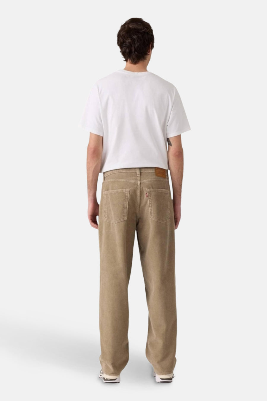 Beige kleurige corduroy broek van Levi's, gezien van achteren, met een wit T-shirt.