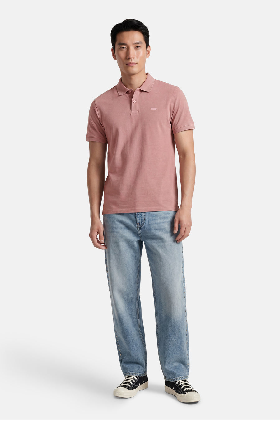 Roze polo van Levi's® met melange textuur, twee knopen en een klein ton-sur-ton logo, gedragen door een man.
