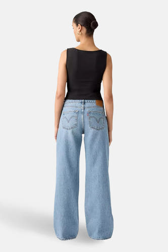 Wijde jeans van midblauw denim van Levi's®, met opgestikte achterzakken en een zwarte top.
