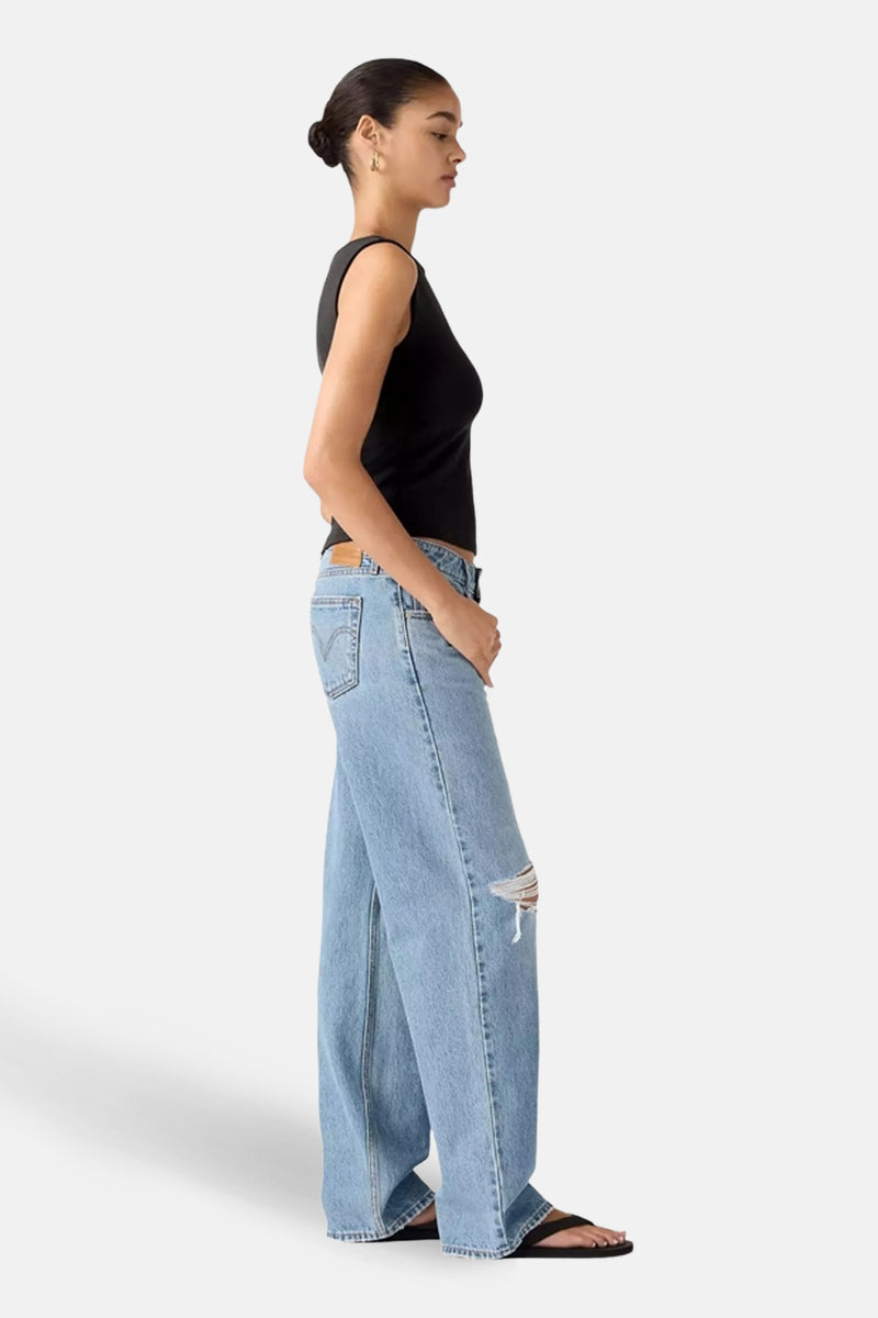 Jeans larges en denim bleu de Levi's®, avec un genou déchiré, combinées avec un débardeur noir.