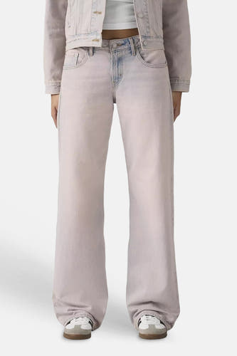 Roze denim colorbroek van Levi's® met wijde pijpen, gestyled met een crop top en sneakers.