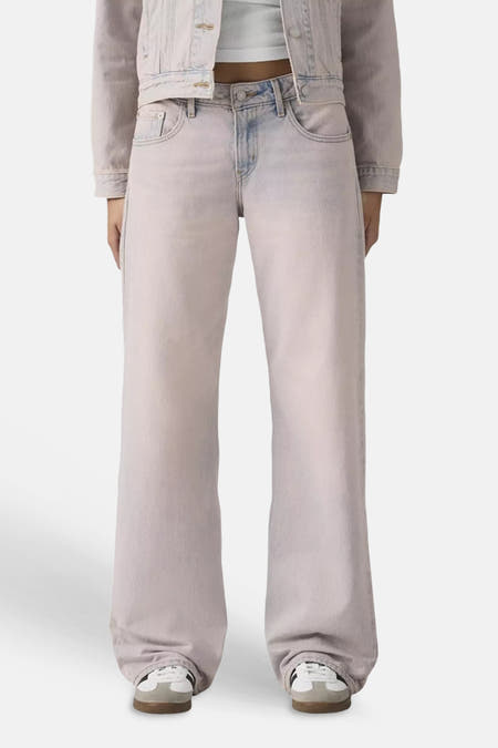 Roze denim colorbroek van Levi's® met wijde pijpen, gestyled met een crop top en sneakers.