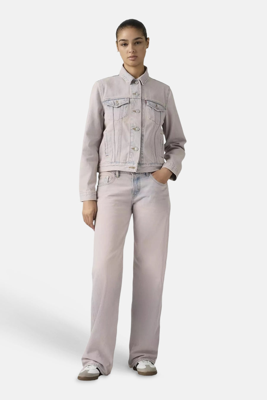 Roze colorbroek van Levi's® met wijde pijpen, gedragen door een model met een bijpassend spijkerjack en witte sneakers.