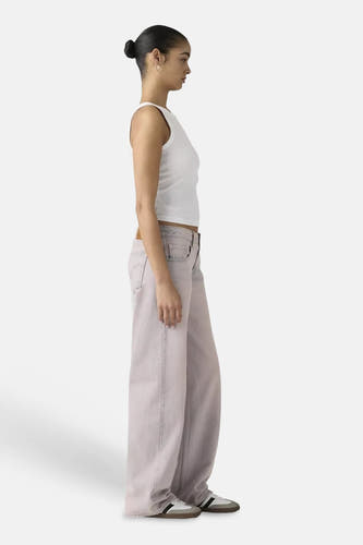 Roze colorbroek van Levi's®, wijde pasvorm, getoond in zijprofiel met witte geribbelde top en sneakers.