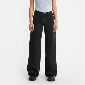 Jean délavé noir de Levi's, associé à une chemise rayée bleue et des chaussures noires.