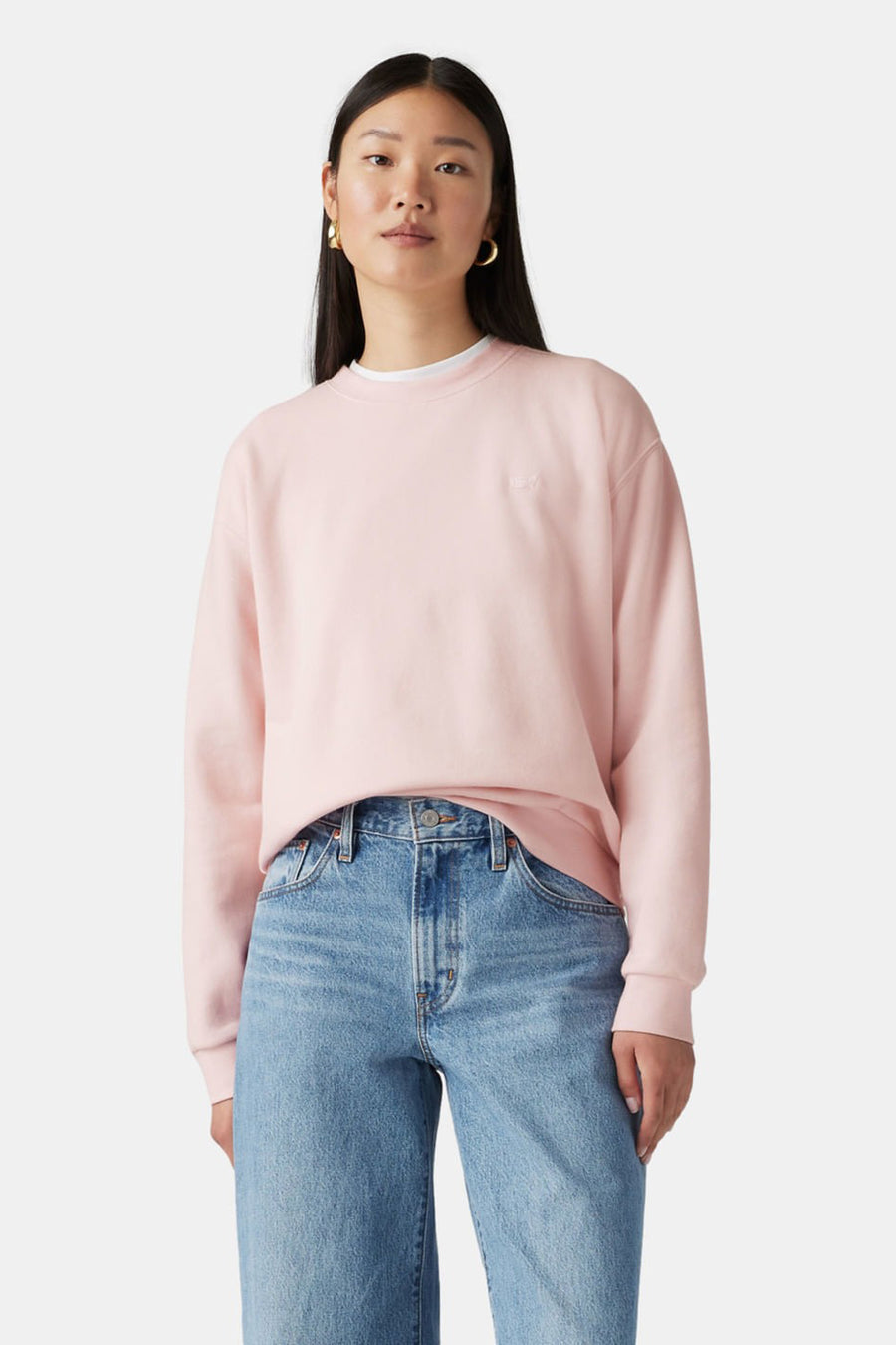 Vrouw met roze sweater en blauwe jeans.