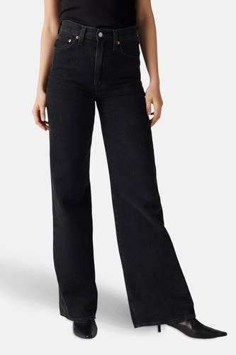 Zwarte wijde jeans van Levi's, gedragen met een zwarte top en zwarte leren laarzen.
