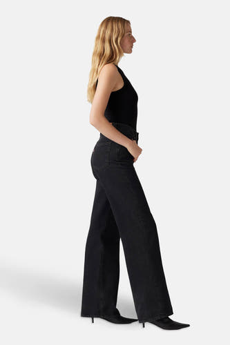 Zwarte wijde jeans van Levi's, gedragen met een zwarte top en zwarte schoenen, in zij-aanzicht.
