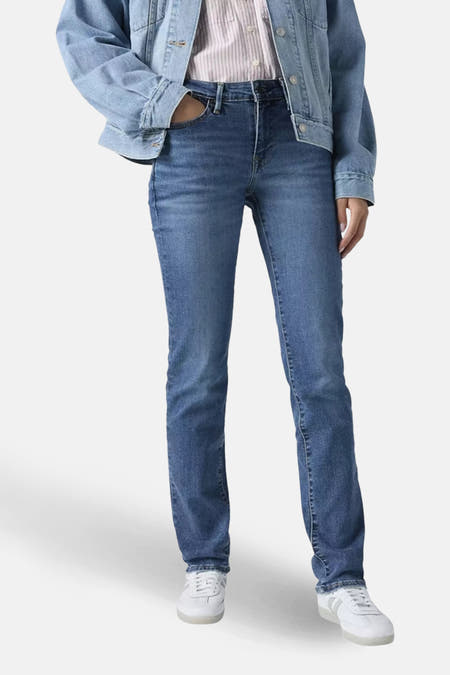 Slim jeans in mid blue denim van Levi's®, gecombineerd met een spijkerjas en witte sneakers.