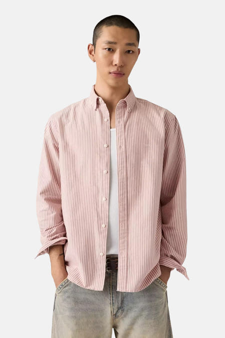 Chemise rose à manches longues de Levi's®, avec des rayures verticales et portée sur un T-shirt blanc.