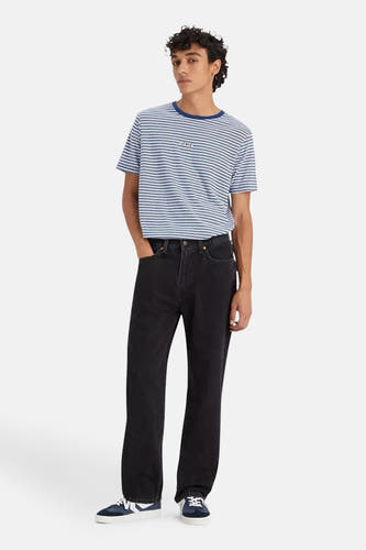 Jeans straight van zwart denim van Levi's, gecombineerd met gestreept shirt en blauwe sneakers.