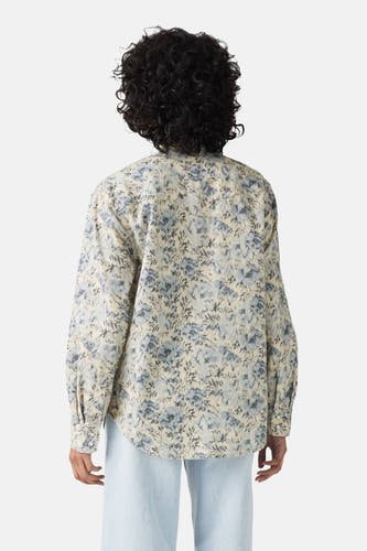 Jeanshemd in blauw van Levi's, met een bloemenpatroon over het hele hemd, gezien van de achterkant.
