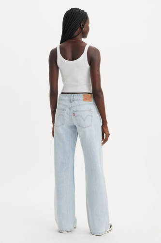 Jean bleu clair droit de Levi's, vu de derrière, associé à un chemisier blanc.