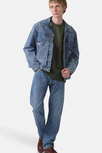 Jeansjas van blauw denim van Levi's, gedragen met groene sweater en blauwe jeans.