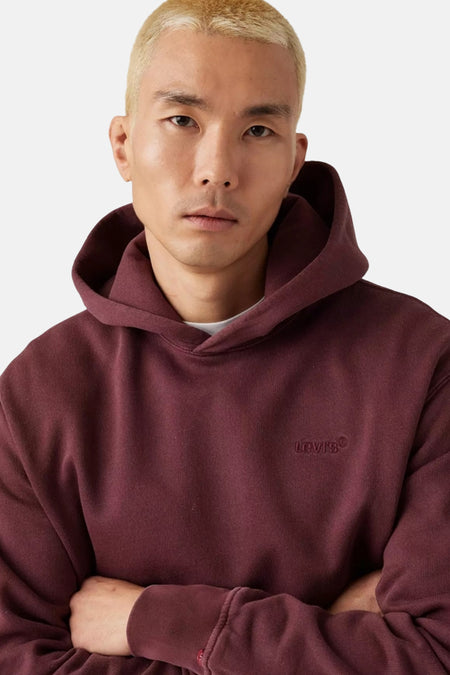 Sweat à capuche bordeaux Levi's® avec logo brodé, coupe confortable, modèle bras croisés, gros plan avant