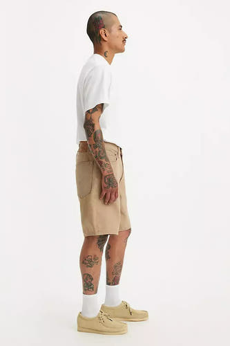 Beige short van Levi's, gedragen met een wit T-shirt, witte sokken en beige schoenen, in zij aanzicht.