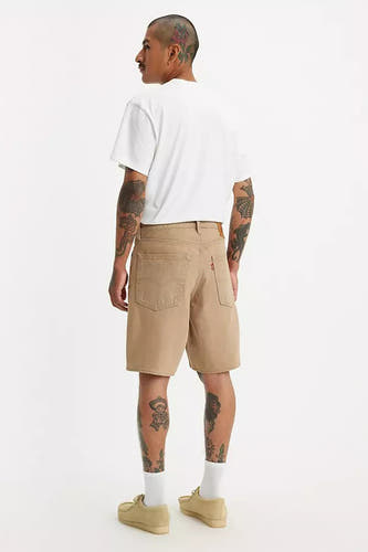 Beige short van Levi's, met achterzakken en gedragen met een wit T-shirt en beige schoenen.
