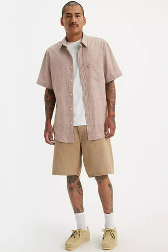 Beige short van Levi's®, gedragen met een wit T-shirt, lichtroze overhemd en crèmekleurige schoenen.