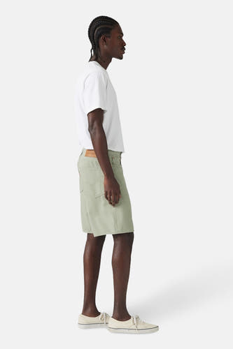 Short vert de Levi's porté avec un avec-shirt blanc et des chaussures crème, en vue latérale.