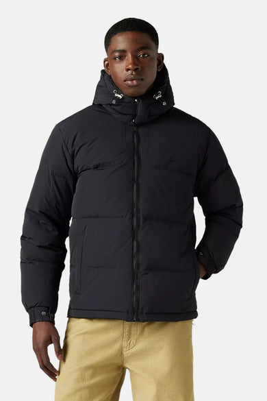Zwarte korte jas van Levi's®, met capuchon en steekzak, gecombineerd met een kaki broek.
