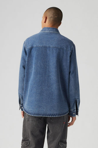 Jeanshemd in mid blue denim van Levi's®, gezien van achteren, met donkergrijze broek.