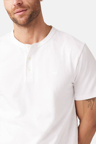 Wit T-shirt met korte mouwen van Levi's®, met een knoopsluiting bij de halslijn en een kleine tattoo op de bovenarm.
