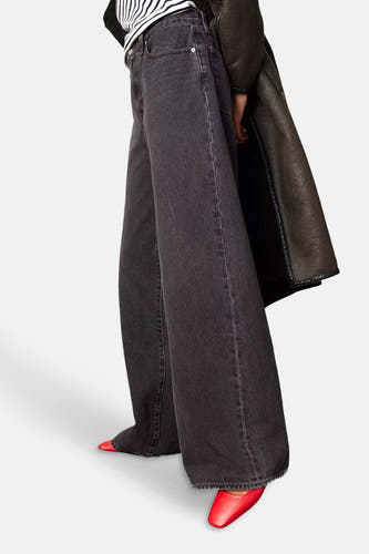 Zwarte straight jeans van Levi's®, met wijde pijpen en rode schoenen.
