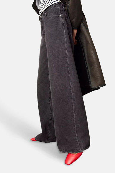 Zwarte straight jeans van Levi's®, met wijde pijpen en rode schoenen.
