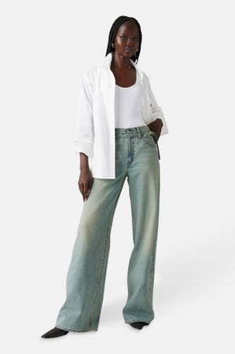 Jean droit en denim bleu clair de Levi's, porté avec un t-shirt blanc et une chemise.